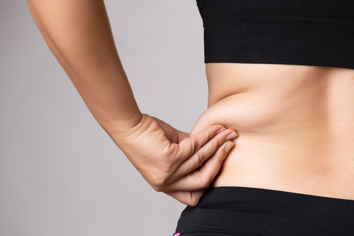 Fat woman hand holding excessive belly fat. Healthcare and woman diet lifestyle concept to reduce belly and shape up healthy stomach muscle. Fat woman hand holding excessive belly fat. Healthcare and woman diet lifestyle concept to reduce belly and shape up healthy stomach muscle.