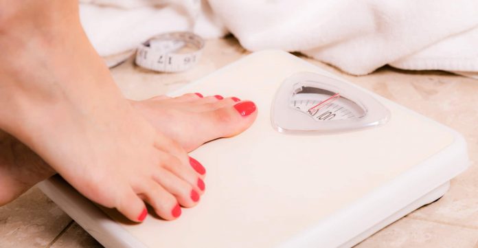 woman-stepping-on-scale-696×361